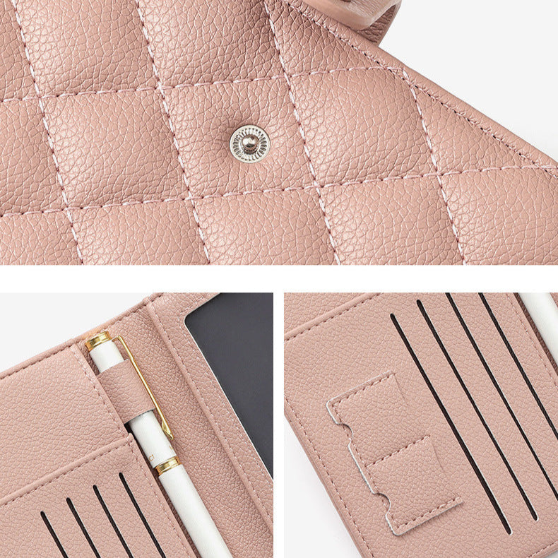 Close-up of a pink quilted leather wallet with a pen holder and button detail.