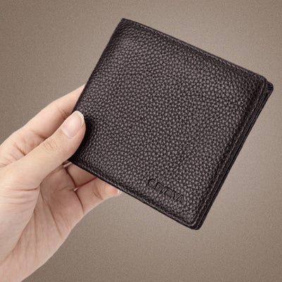 Hand holding a textured black wallet against a brown background with Chinese text.